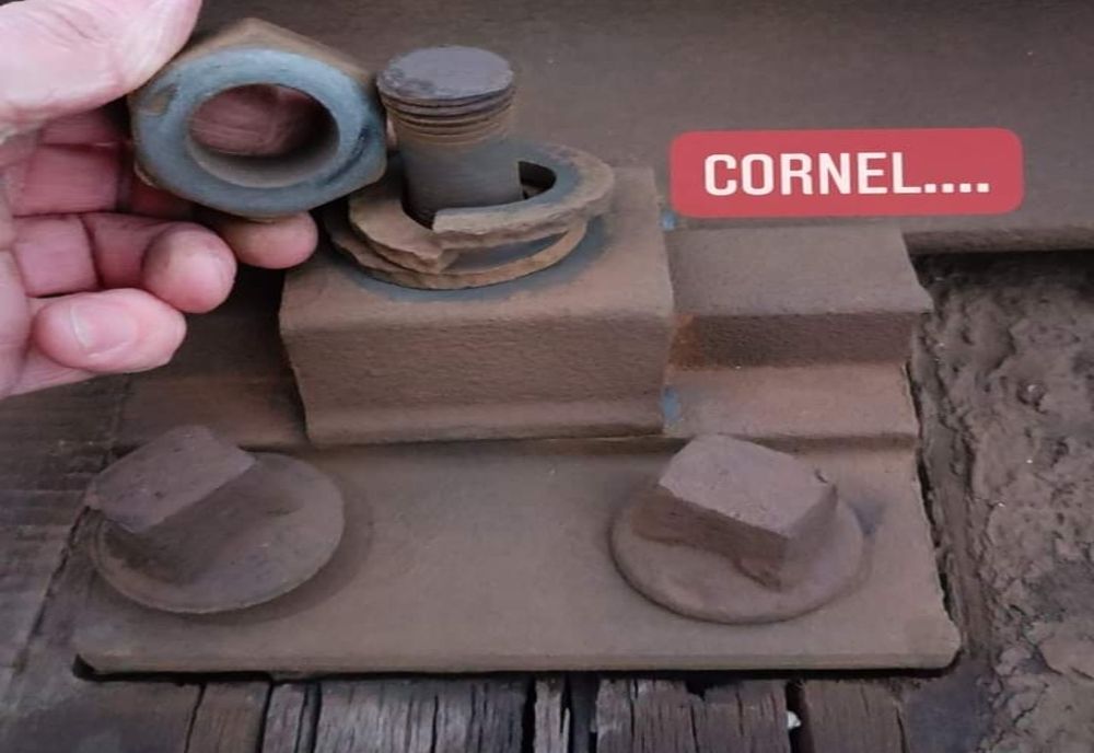 Magistrală în pericol, spune un mehedințean care desface, cu mâna liberă, mai multe șuruburi de pe marginea căii ferate 